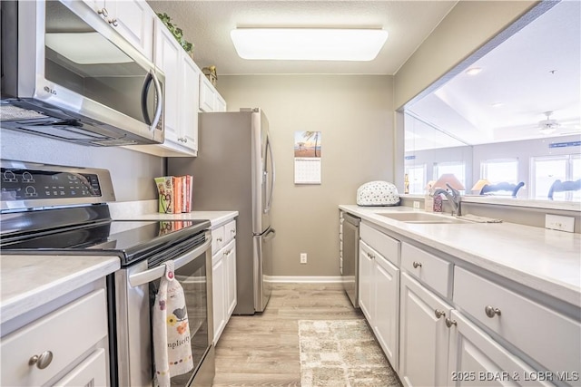 214 Emerald Bay Dr Unit 1D, Lake Ozark, MO 65049 - kitchen featuring stainless steel appliances, white cabinets, light wood finished floors, and light countertops