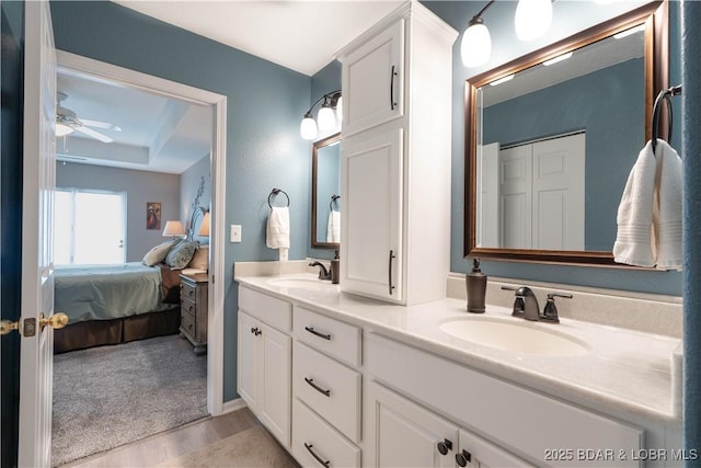 214 Emerald Bay Dr Unit 1D, Lake Ozark, MO 65049 - ensuite bathroom with double vanity, ceiling fan, and wood finished floors