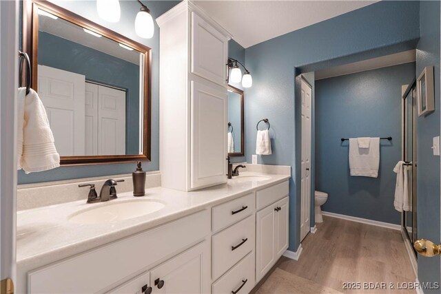 214 Emerald Bay Dr Unit 1D, Lake Ozark, MO 65049 - bathroom featuring double vanity and wood finished floors