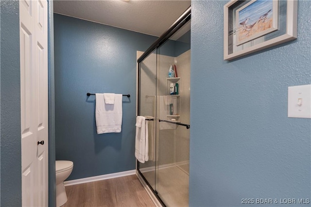 214 Emerald Bay Dr Unit 1D, Lake Ozark, MO 65049 - bathroom with wood finished floors, a shower stall, and a textured wall