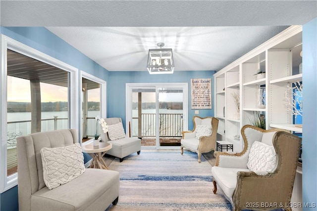 sitting room with a chandelier and wood finished floors