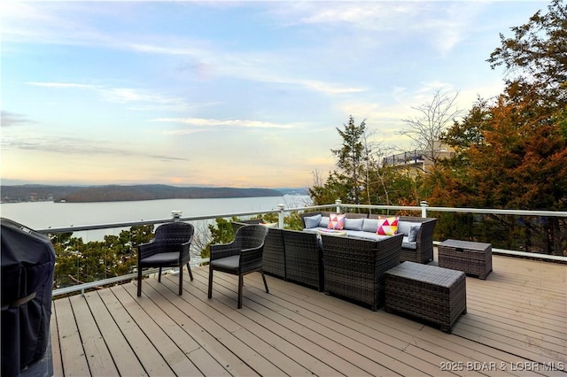 deck with an outdoor living space, a water view, and grilling area