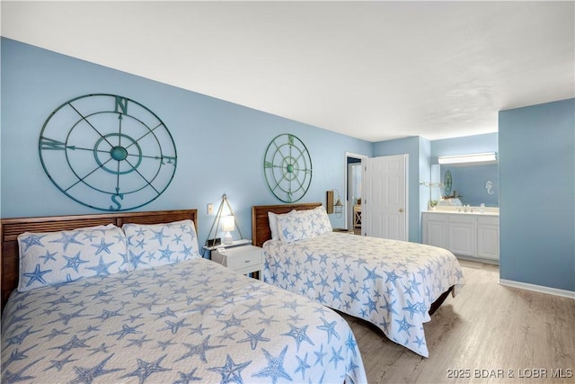 bedroom featuring light wood-style flooring, baseboards, and ensuite bathroom