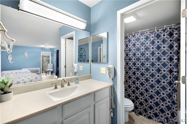 ensuite bathroom with toilet, vanity, and curtained shower