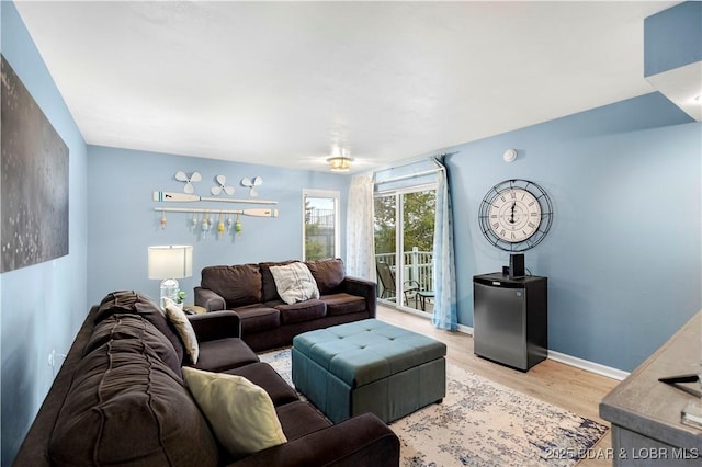 living area with light wood-style flooring and baseboards