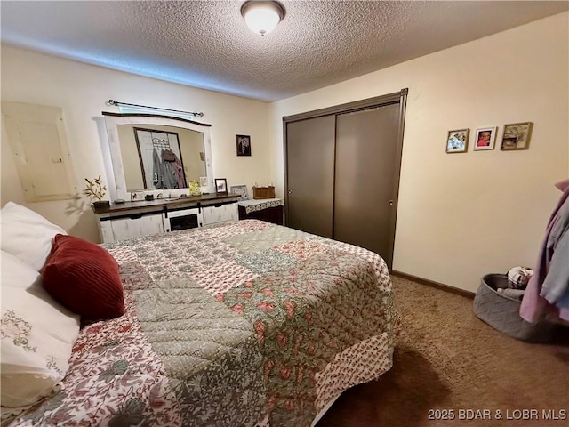 bedroom with carpet, a closet, a textured ceiling, and baseboards