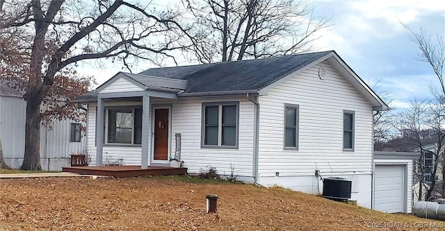 view of front of home featuring covered porch, central air condition unit, and a shingled roof