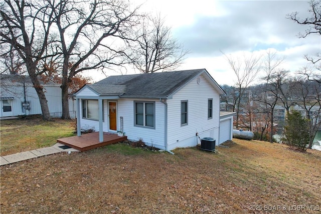 bungalow-style house with central AC unit, a shingled roof, a front yard, and a garage