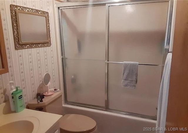 full bath featuring vanity, shower / bath combination with glass door, toilet, and wallpapered walls