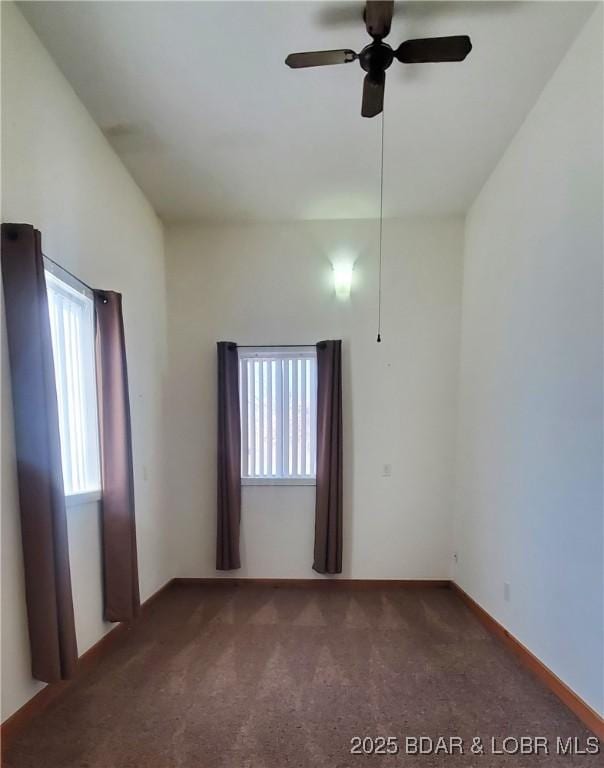 unfurnished room featuring plenty of natural light, carpet flooring, a ceiling fan, and baseboards