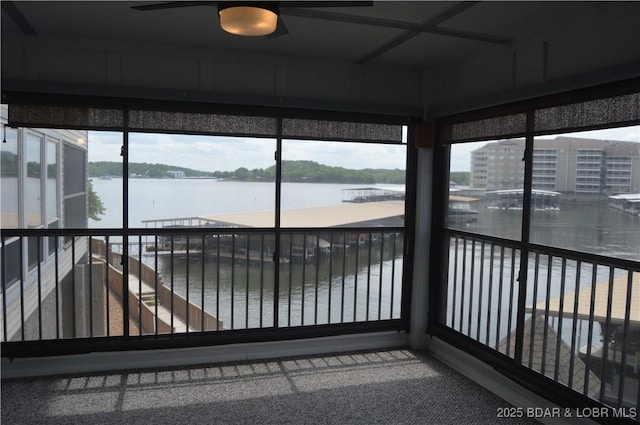 unfurnished sunroom with a water view, healthy amount of natural light, and carpet flooring
