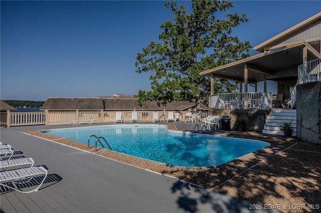 community pool featuring stairs and a patio