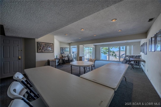 carpeted dining area with a textured ceiling, baseboards, and recessed lighting