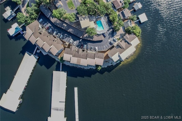 aerial view of property and surrounding area featuring a pool area and a nearby body of water
