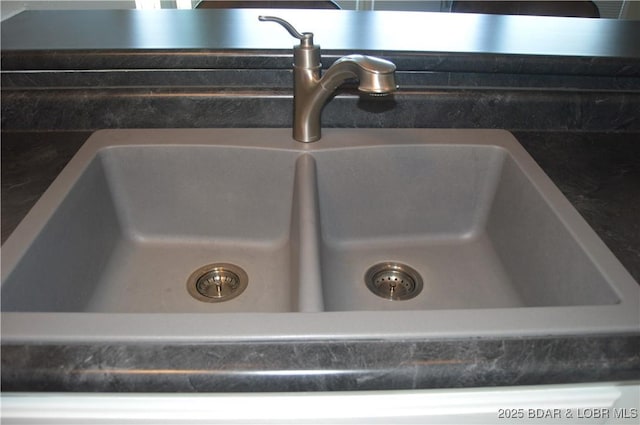 kitchen view of a sink and dark countertops