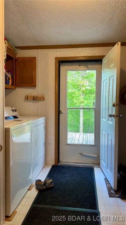 29745 Canary Rd, Gravois Mills, MO 65037 - clothes washing area with washer and dryer, a textured ceiling, and cabinet space