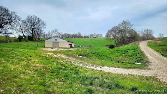 25455 Rail Rd, Richland, MO 65556 - view of yard featuring a pole building, a detached garage, a view of countryside, an outdoor structure, and dirt driveway