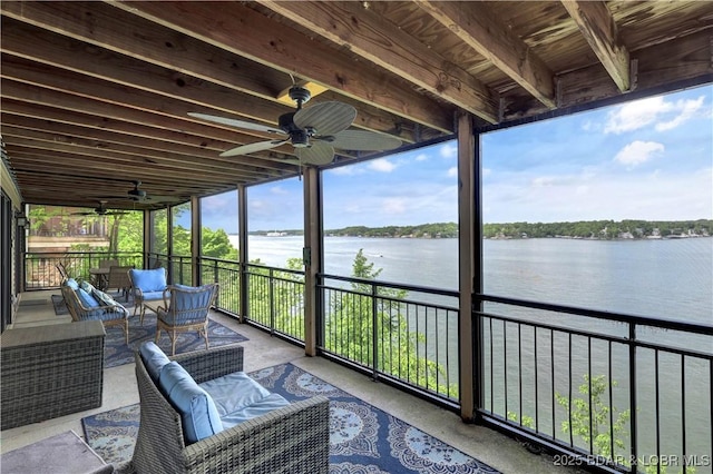 sunroom featuring ceiling fan, a water view, and an outdoor living space