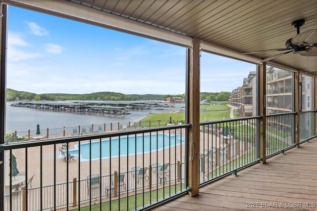 wooden deck with a water view and a ceiling fan