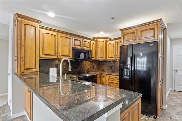 kitchen with black appliances, baseboards, brown cabinetry, a peninsula, and dark stone counters