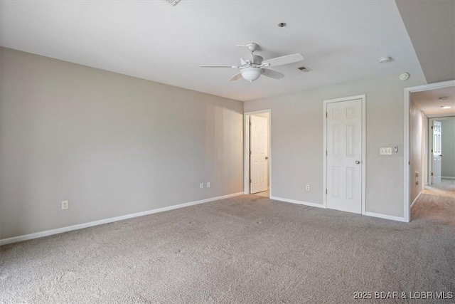 empty room featuring carpet flooring, ceiling fan, baseboards, and a smoke detector