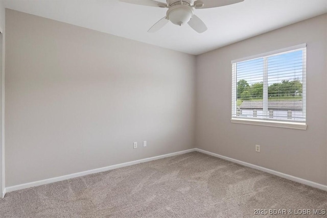 carpeted empty room featuring baseboards and ceiling fan