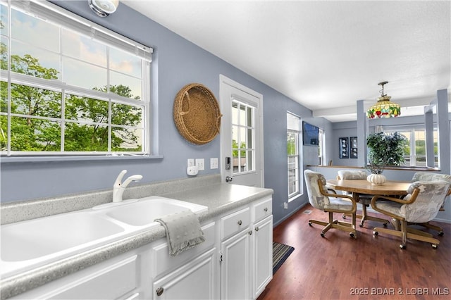 35 Teak Village Dr, Lake Ozark, MO 65049 - kitchen with light countertops, white cabinets, dark wood-style floors, and a sink