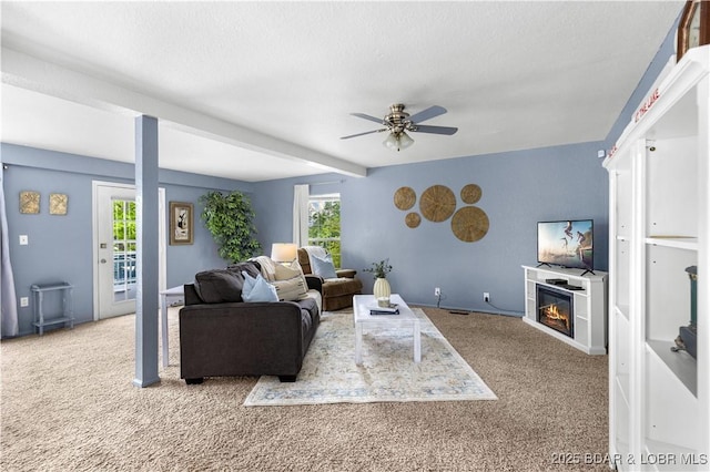 35 Teak Village Dr, Lake Ozark, MO 65049 - living room featuring carpet floors, a ceiling fan, and a glass covered fireplace