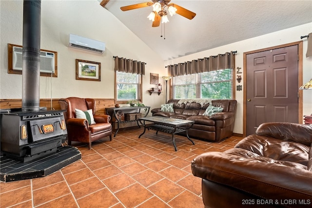 108 Frazier Oaks Rd, Eldon, MO 65026 - tiled living room featuring a wood stove, an AC wall unit, a ceiling fan, high vaulted ceiling, and a wall unit AC