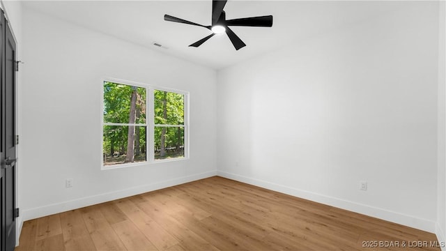 spare room featuring baseboards, light wood-type flooring, and ceiling fan