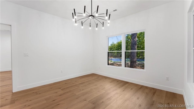 unfurnished dining area with a chandelier, light wood finished floors, and baseboards