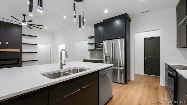kitchen featuring a sink, stainless steel appliances, light countertops, open shelves, and recessed lighting