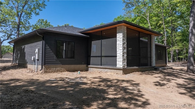 rear view of house featuring a sunroom