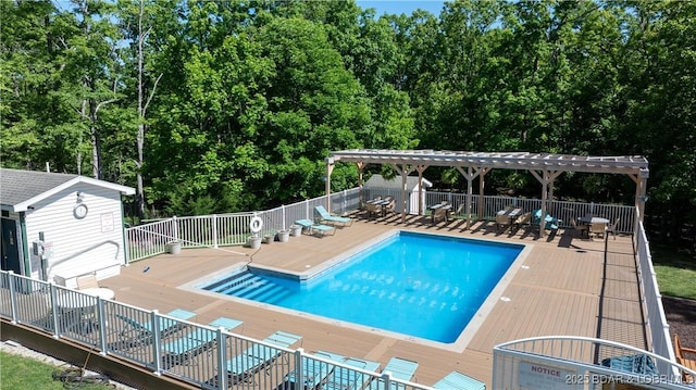 community pool with a wooden deck, fence, a pergola, an outdoor structure, and a shed
