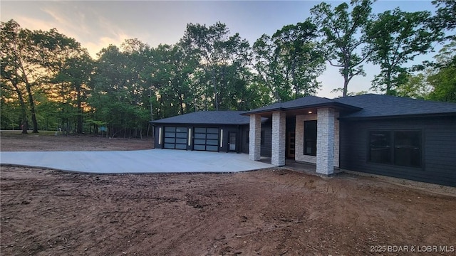 back of property featuring concrete driveway and an attached garage