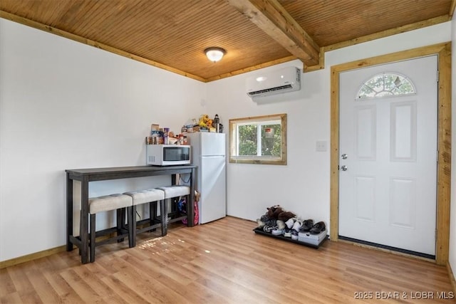 entrance foyer featuring wood ceiling, a wall mounted AC, plenty of natural light, light wood-style floors, and beamed ceiling