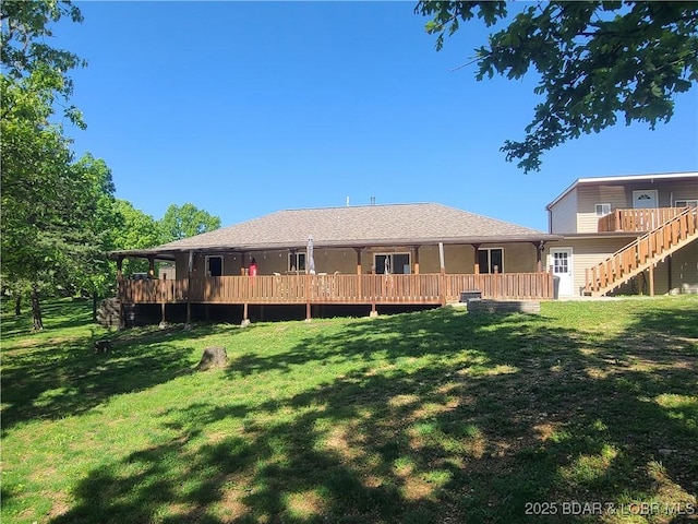 rear view of house with a lawn and a wooden deck