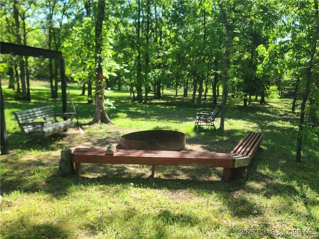 view of grassy yard with a fire pit