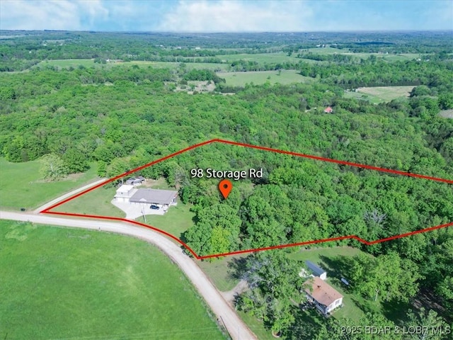 aerial view of property's location featuring a heavily wooded area and property parcel outlined