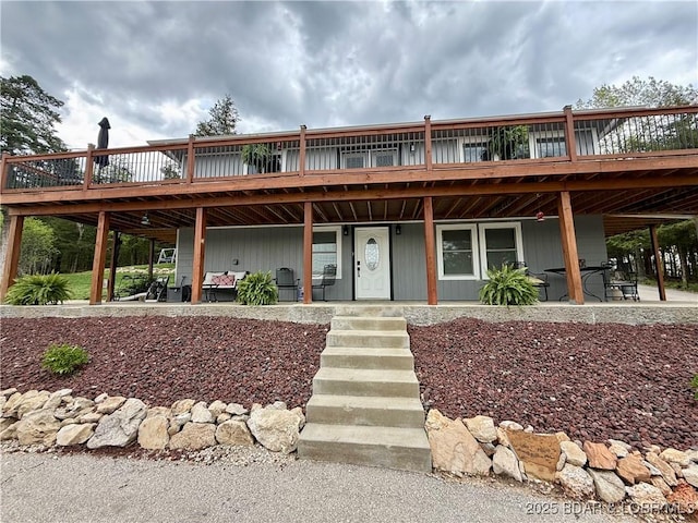 view of front of house with a wooden deck and a patio