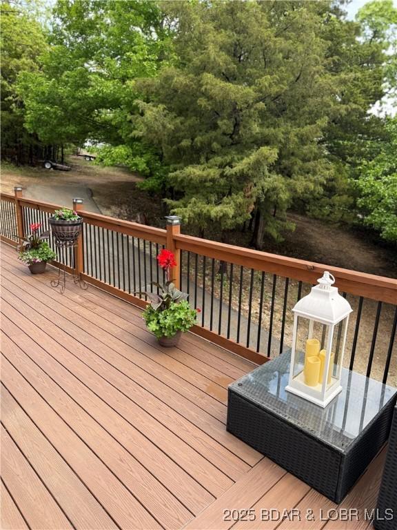 wooden deck with view of wooded area