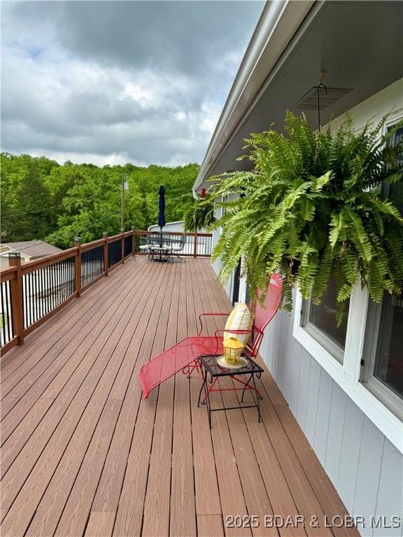 wooden deck with a wooded view