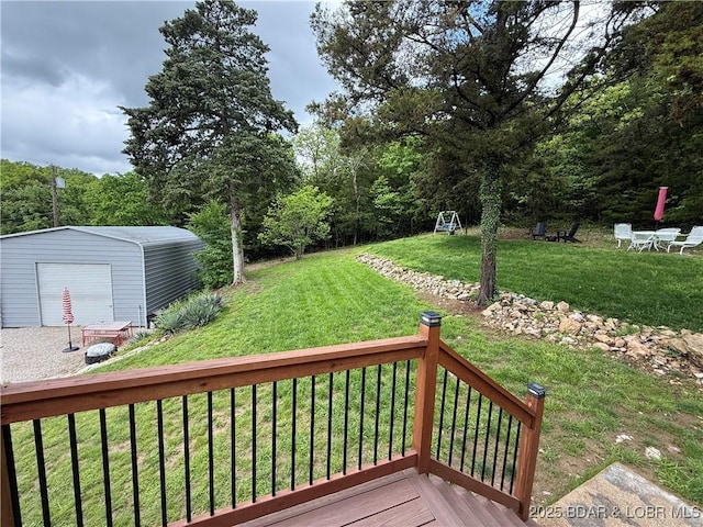 wooden deck featuring a lawn, an outdoor structure, a garage, and a shed
