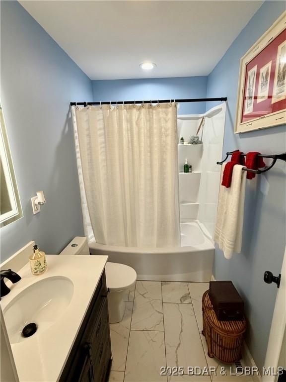 full bathroom featuring marble finish flooring, shower / tub combo with curtain, vanity, and toilet