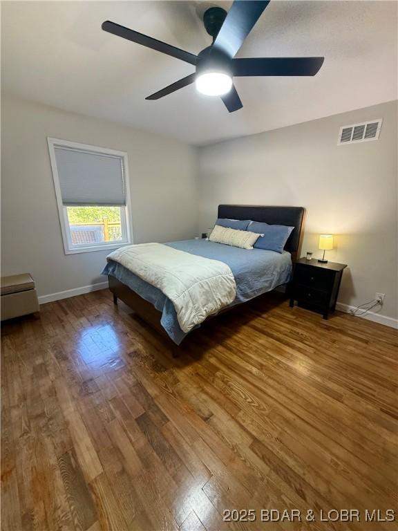 bedroom with wood finished floors, baseboards, and a ceiling fan