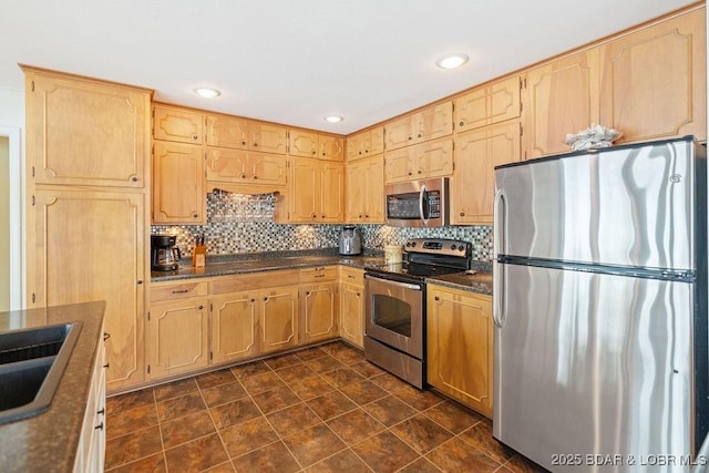kitchen with appliances with stainless steel finishes, tasteful backsplash, a sink, light brown cabinetry, and recessed lighting