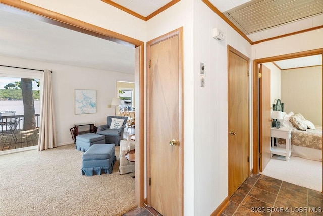 corridor with dark colored carpet and ornamental molding