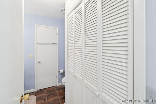 hall with wallpapered walls and baseboards