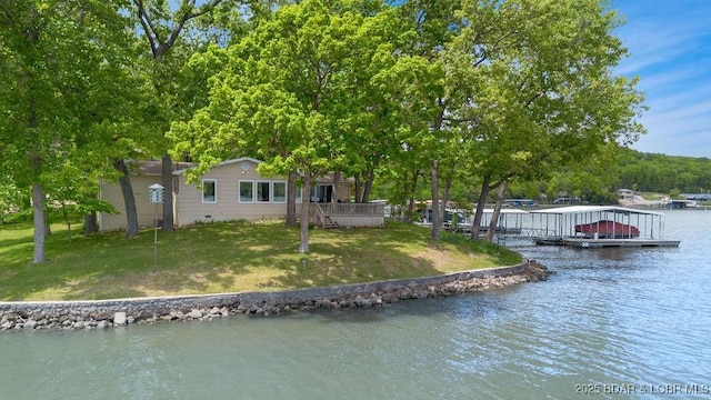 dock area with a water view and a lawn