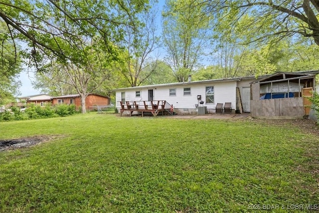 back of house with a wooden deck, a yard, and central air condition unit